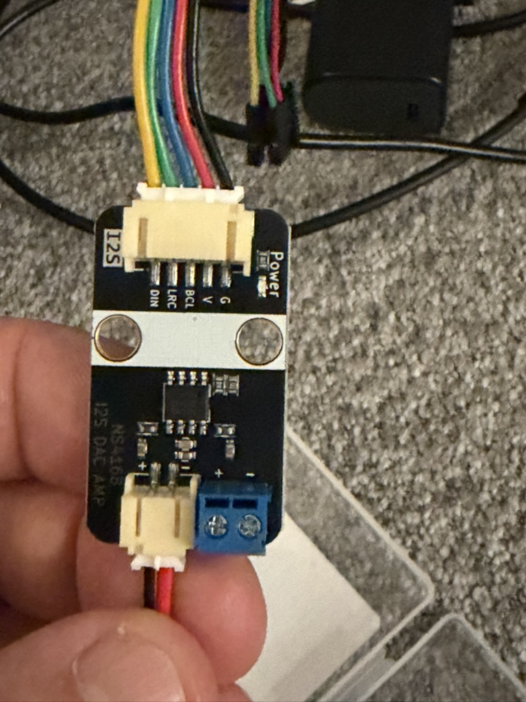 Herald's microphone module held in hand, rainbow jumper wires connected